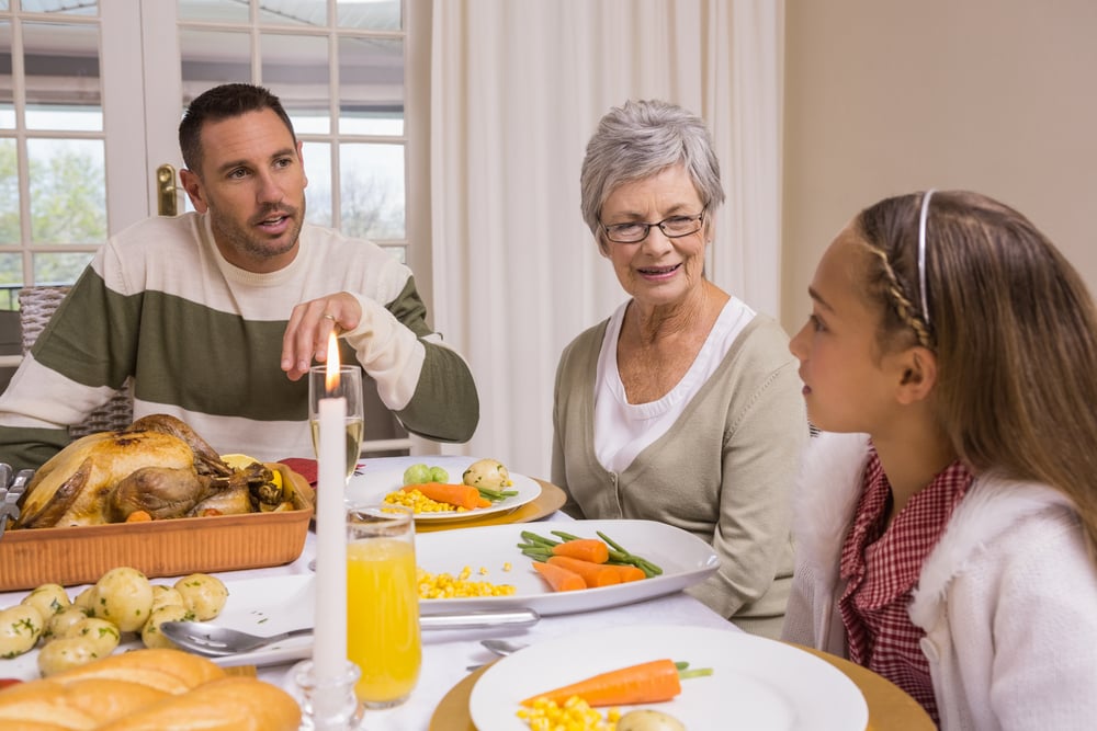 daughter, grandmother, and father talking at dinner