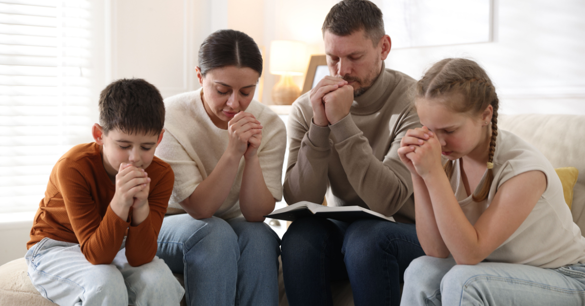 Family of four praying together