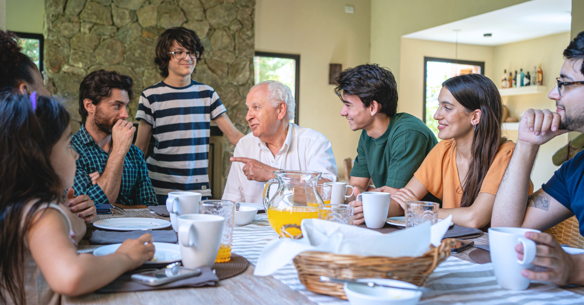 Multi-generational family eating dinner at table and talking